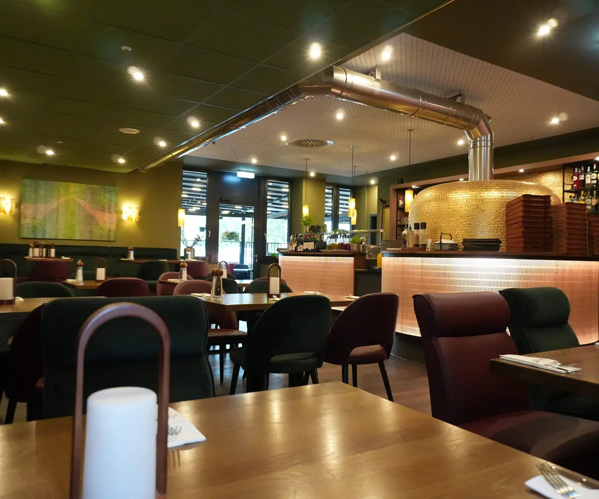 Gedeckte Tische, Bar und Pizzaofen in der Osteria Siros