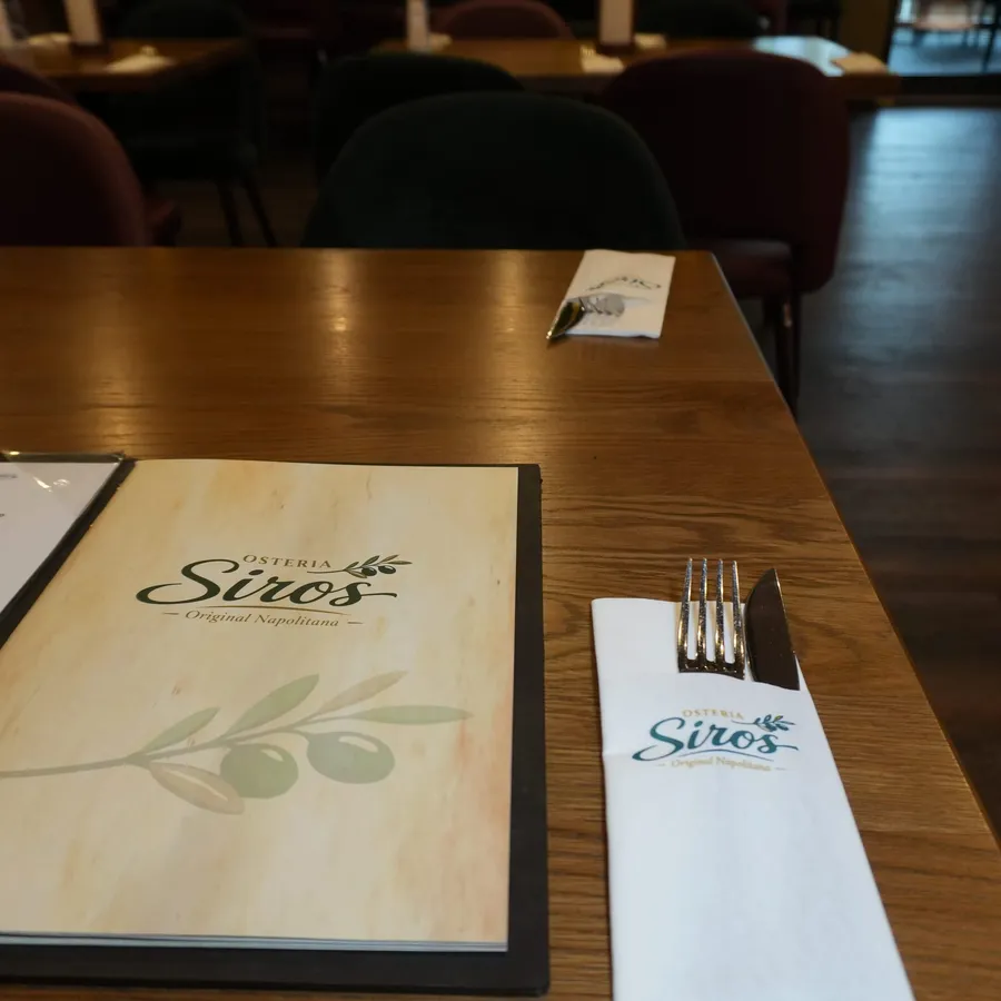 Speisekarte und Besteck auf einem gedeckten Tisch